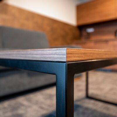 Nowoczesny, metalowy stelaż do stołu z drewnianym blatem w minimalistycznym wnętrzu.