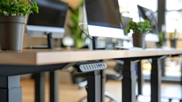 Biurka z roślinami i komputerami, z stelażem biurka z regulacją wysokości.